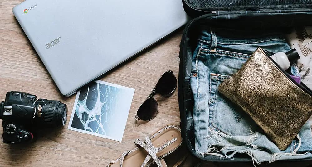 Suitcase, laptop and other travel gear on the floor