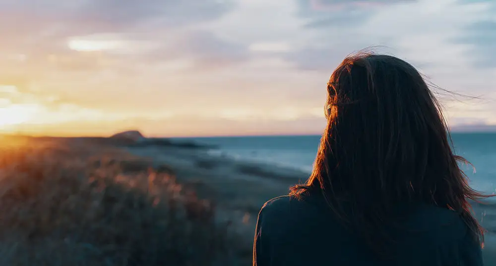 woman-looking-out-to-majestic-sea