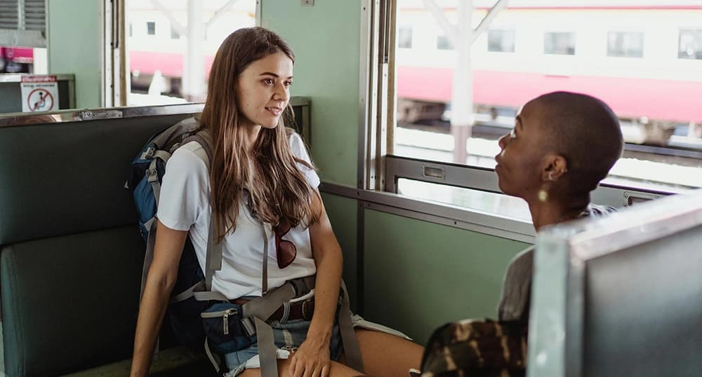 Travelers chatting on a train.