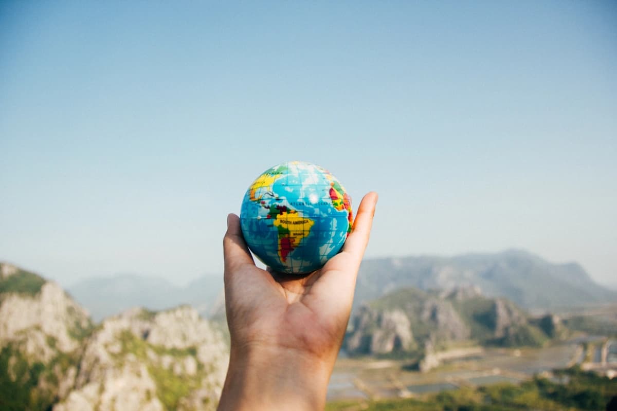 Hand holding up a tiny globe